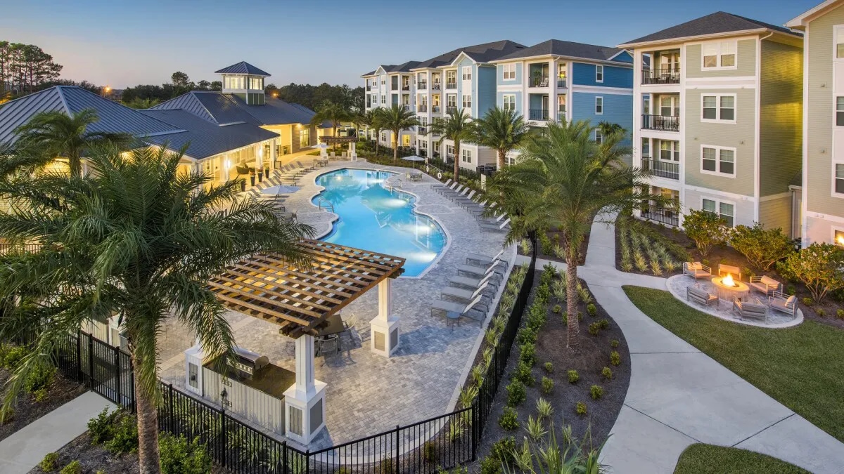 Multifamily property with a pool and palm trees - Point at Tamaya in Jacksonville, Florida
