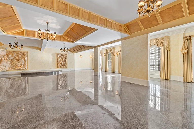 Grand ballroom with polished marble floors, coffered ceiling, and ornate chandeliers at the Atlanta White House event and wedding venue.