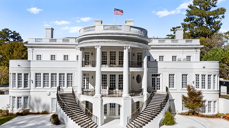 MExterior view of the Atlanta White House mansion with white columns, dual staircases, and American flag, resembling 1600 Pennsylvania Avenue in Atlanta, Georgia