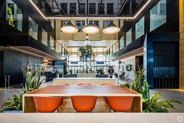 Modern lobby interior of Anchorage Two, Salford, featuring flexible seating, indoor plants, and natural light in a 4-star office building.