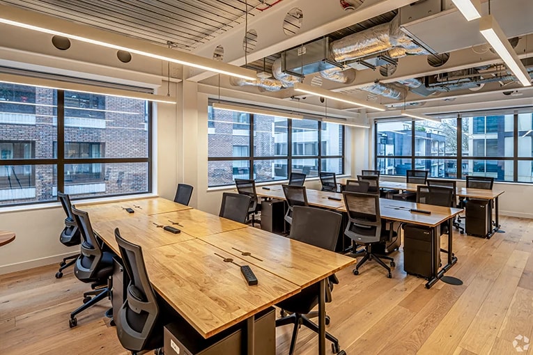 Open coworking space in the UK featuring shared desks, natural lighting, and a modern, collaborative layout.