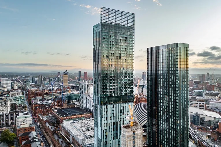 Aerial view of Manchester city centre with modern towers and surrounding commercial buildings.