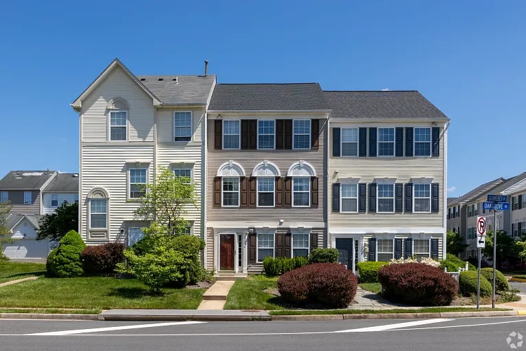 Three-story residential townhomes commonly transferred with warranty deeds, representing clear title ownership in real estate transactions.